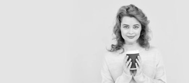 İzole edilmiş yüz portresi, fotokopi alanı olan pankart. Biraz daha kahve. İçeceklerinizi alın. Neşeli kız çay içiyor. Kadın plastik bardağı cappuccino ile tutuyor.