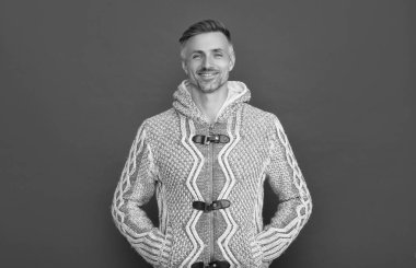 Mutlu yakışıklı adam kırmızı arka planda süveter giyer, erkek güzeli.