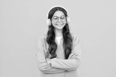 Funny kid girl 12, 13, 14 years old listen music with headphones. Teenage girl with headphones listening songs on headset earphone