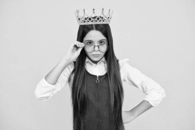 Teen child in queen crown isolated on yellow background. Princess girl in tiara. Teenage girl wear diadem. Serious teenager girl