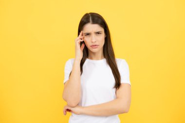 Stres ya da baş ağrısı çeken genç bir kadının portresi. Yorgun, çaresiz ve stresli bir kız. Acı ve migren yüzünden. Üzgün depresif model, elleri başının üstünde.