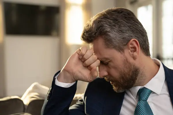 Yorgun bir adam, elinde gözlük tutarken acı hisseder. Bilgisayarda çalışmaktan yorgun düşmüştür. Stresli bir adam baş ağrısı ve görme sorunu yaşar. Son teslim tarihi ve stresli iş