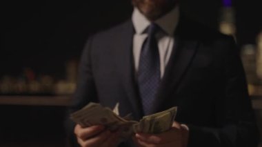 İş adamı paraya yatırım yapar. Başarılı iş para getirir. Başarılı bir iş adamı yatırımcı. Finansal yatırım. Başarılı bir iş. İş adamı dışarıda para sayıyor. Seçici odak.