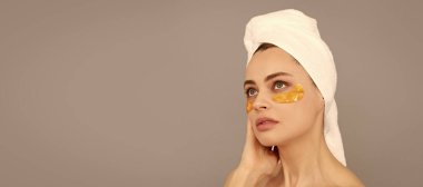 Göz bandı. Cildi parlıyor. Kız göz torbalarını küçültür. Cilt bakımı. Yüz kolajeni kozmetiği. Nemlendirici cilt. Güzel kadın, izole edilmiş yüz portresi, taklit alanı olan pankart.