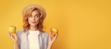Yaz elması. İzole edilmiş bir yüz portresi, taklit alanı olan bir afiş. Hasır şapkalı kadın sağlıklı yemek yiyor. Gençlik sağlığı. Doğal organik taze elma