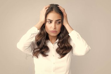 Stres ya da baş ağrısı çeken genç bir kadının portresi. Yorgun, çaresiz ve stresli bir kız. Acı ve migren yüzünden. Üzgün depresif model, elleri başının üstünde.