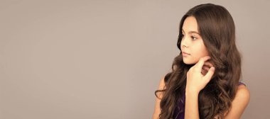 Uzun kıvırcık saçlı çocuk portresi. Yüzüne dokun, güzelim. Çocuk yüzü, yatay poster, izole edilmiş genç kız portresi, fotokopi alanı olan pankart