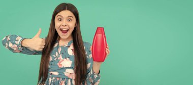 Şaşırmış, uzun saçlı, şampuan şişesi tutan çocuk baş parmağını kaldır, cilt bakımı. Çocuk saçı bakımı afişi, fotokopi alanı olan poster başlığı