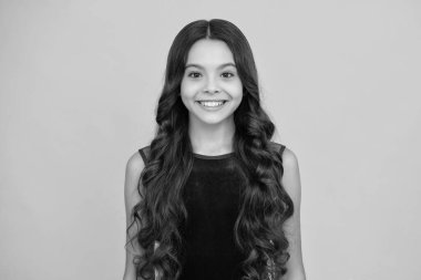 Happy girl face, positive and smiling emotions. Cute young teenager girl against a isolated background. Studio portrait of pretty beautiful child