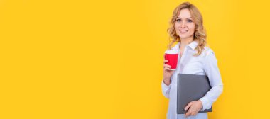 Sarı arka planda, kahve fincanı ve dizüstü bilgisayarı olan gülümseyen sarışın kadın. İzole edilmiş yüz portresi, taklit alanı olan pankart