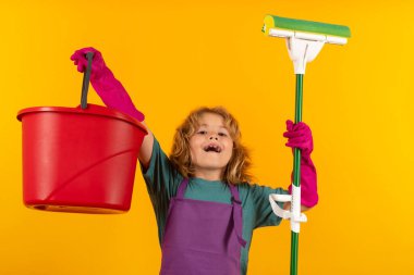 Çocuk ev işlerine yardım ediyor, evi temizliyor. Aksesuar temizleme, temizlik malzemeleri. Ev işlerine yardım eden, evi temizleyen çocuk portresi. Oda servisi, ev işleri.