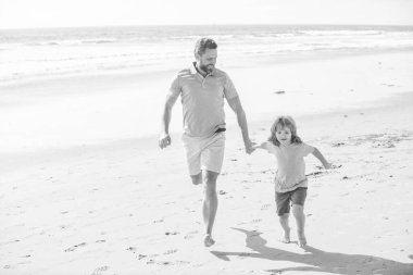 Mutlu çocuk ve baba yaz tatilinde plajda koşuyorlar, yaşam tarzları..