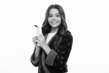 Şampuan kremi kullanan bir çocuk. Günlük kozmetik bakım. Gençlerin elinde saç ve cilt bakımı şişesi var. Güzellik sağlığı ve kozmetik ürünleri. Mutlu kız yüzü, pozitif ve gülümseyen duygular