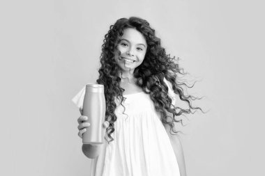 Şampuanlı ve duş jöleli genç bir kızın mutlu portresi. Genç kızın uzun saçı. Kozmetik ürünler, şampuan şişesi. Gülümseyen kız