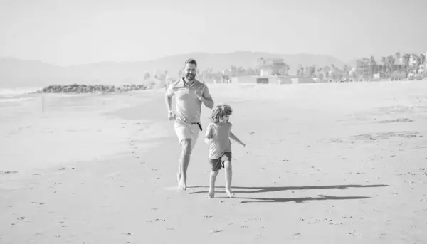 dad and kid boy family running on summer beach, family vacation.