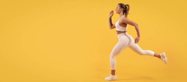 Sarı arka planda koşan aktif sporcu kadın koşucu. Kopyalama alanı ile çalışan kadın pankartı