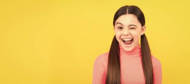 Sarı arka planda uzun saçlı göz kırpan çocuk, duygular. Çocuk yüzü, yatay poster, izole edilmiş genç kız portresi, fotokopi alanı olan pankart