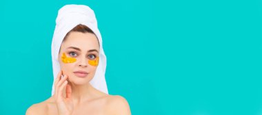 Cilt bakımlı güzel kadın. Yüzünde altın rengi kolajen bandı olan genç bir kadın. Güzel kadın, izole edilmiş yüz portresi, taklit alanı olan pankart.