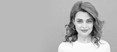 Mavi arka planda kıvırcık saçlı, gülümseyen kızıl saçlı kadın. İzole edilmiş yüz portresi, kopyalama alanı olan pankart