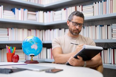 Okul sınıfında öğretmen öğretmeni. Bilgi, eğitim. Sınıfta ders veren bir adam. Üniversite sınavı. Üniversitede ders veriyorum. Eğitimci öğrenme kursları. Edebiyat okuyorum. Öğretmenler Günü