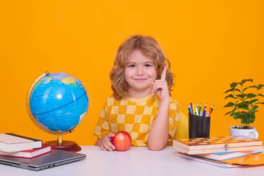 Okullu çocuk harika bir fikirle işaret parmağını kaldırıyor. Okul çocukları. İlkokuldan bir çocuk. Öğrenci, git çalış. Zeki okul çocuğu öğreniyor. Çocuklar eğitim, bilgi ve eğitim kavramı