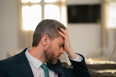 Bilgisayar çalışmalarından sonra baş ağrısı çeken yorgun bir adam. Kafaya dokunmaktan yorgun düşmüş, baş ağrısını dindirmiş, migren olmuş. İş sorunları. İflas, mali sorun ve kriz kavramı