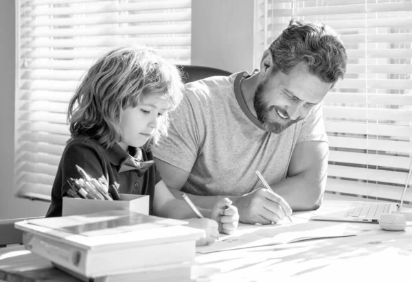 private writing lesson. education concept. homeschooling and self-education. back to school. concentrated father and son painting at home. family help. boy do homework with teacher.