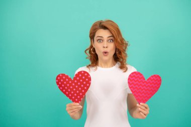 Mavi arka planda kırmızı kalbi olan genç bir kız..