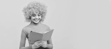 Pembe polonezli turuncu saçlı mutlu kız gülümsemesi okul kitabı okuyor, bilgi sahibi. Partideki komik genç çocuk, afiş başlığı fotokopi alanı