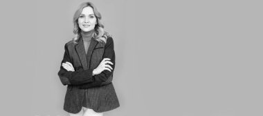 Kadın portresi, kopyalanmış başlık pankartı. Gri arka planda İngiliz elbiseli gülümseyen iş kadını. Ceketli neşeli sarışın kadın.