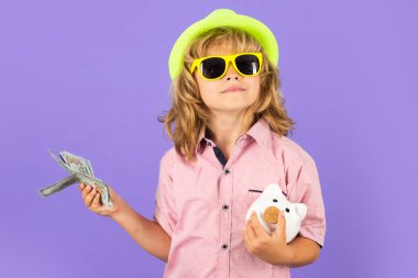 Dolar parası ve kumbara konsepti. Çocuk para biriktirmek için kumbaraya para koyuyor. Bozuk paralar ve çocuk konseptiyle domuz kumbarası