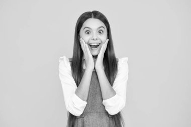 Heyecanlı bir yüz. Şaşırtıcı bir ifade, neşeli ve mutlu. Stüdyonun sarı arka planında izole edilmiş Kafkas ergen kız çocuğunun duygusal portresi