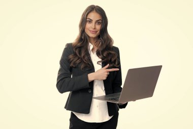 Gri arka planda dizüstü bilgisayarı olan mutlu bir iş kadınının portresi.