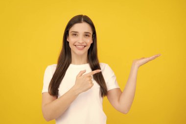 Kadın fotokopi alanını işaret ediyor, kopyalama alanını gösteriyor. Promosyon, reklam içerikli jest gösteren kız, elle tavsiye edilen ürünü işaret ediyor. İzole edilmiş arkaplan