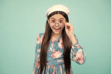 Gözlüklü genç kız portresi. Göz testindeki çocuk. Gözlüklü ve kameraya bakan kız. Çocuklar için vizyon. Mutlu ergen, pozitif ve gülümseyen duygular