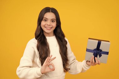 İzole edilmiş arka planda hediye kutusu olan çocuk. Doğum günü hediyeleri, sevgililer günü, yeni yıl ya da Noel. Mutlu yüz, pozitif ve gülümseyen genç kız duyguları