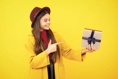 Mutlu ergen portresi. Tecrit edilmiş bir geçmişi olan 12-14 yaşlarında bir kız çocuğu. Doğum günü, tatil konsepti. Gençler hediye kutusunu tutar. Gülümseyen kız