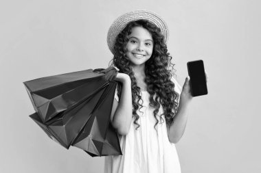 Alışveriş çantaları ve cep telefonuyla şık bir genç kız. Alım satım yapan çocuk. Mutlu ergen, pozitif ve gülümseyen genç kız duyguları