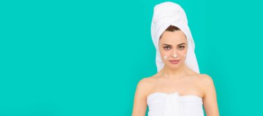 Genç bayan mavi arka plana krem sürüyor. Güzel kadın, izole edilmiş yüz portresi, taklit alanı olan pankart.