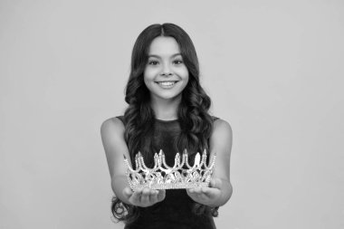 Altın taç takan küçük kraliçe. Tacını tutan genç kız prenses. Balo partisi, çocukluk konsepti. Mutlu kız yüzü, pozitif ve gülümseyen duygular