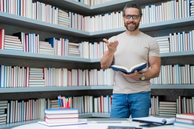 Öğretmenler günü. Öğretmenim okulda. Orta yaşlı öğretmenle bilgi ve eğitim. Kitaplı İspanyol öğretmen. Sınıfta ders veren adam. Üniversite sınavındaki öğretmen. Üniversite öğretmenleri