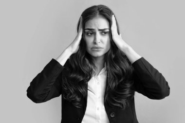 Stres ya da baş ağrısı çeken genç bir kadının portresi. Yorgun, çaresiz ve stresli bir kız. Acı ve migren yüzünden. Üzgün depresif model, elleri başının üstünde.
