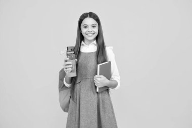 Cute school girl with backpack holding water bottle