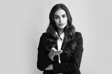İş kadını portresi. Çekici, oldukça neşeli takım elbiseli iş kadını, izole, gri bir geçmişi var. Kadın ofis çalışanı, başarılı menajer.