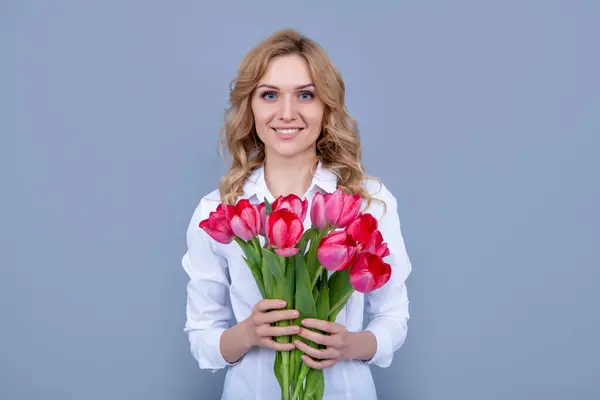 stock image cheerful girl with spring tulip flowers on grey background.
