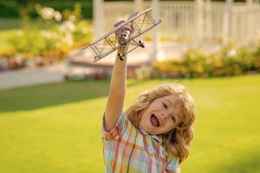 Çocuk çocuk oyuncak uçakla oynuyor ve geleceği hayal ediyor. Mutlu pilot çocuk uçakla dışarıda oynuyor.