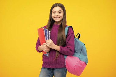 Okula dönelim. Liseli kız, sarı izole stüdyo geçmişi üzerine kitap tutuyor. Okul ve eğitim kavramı. Okul üniformalı ergen kız.