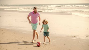 daddy with kid boy on good summer day. weekend family day. dad and child having fun outdoors. childhood and parenting. family holidays. sport activity. father and son play football on beach.