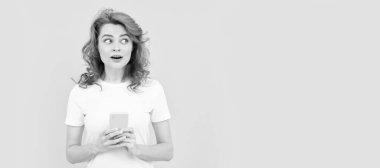 İzole edilmiş bir yüz portresi, taklit alanı olan bir afiş. Şaşırmış kızıl saçlı kadın akıllı telefonda sohbet ediyor ya da online alışveriş yapıyor, iletişim kuruyor.