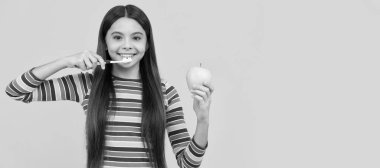 Mutlu kız diş fırçasıyla diş fırçası, elma sarısı arka plan, sağlıklı dişler. Diş fırçası, stüdyo resmi, fotokopi alanı ile başlık